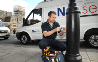 Norse employee fixing a street lamp